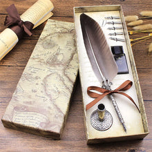 Feather quill pen set with ink bottle and accessories in a decorative box on a wooden surface.