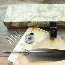 Feather pen with inkwell and ink bottles on a wooden surface