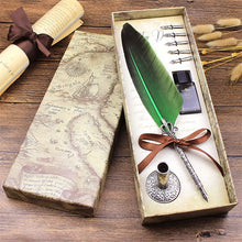 Decorative feather pen set with ink bottle in a box on a wooden surface