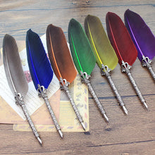 Set of feather quill pens with metallic tips on a wooden surface