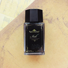 Black ink bottle with decorative label on a textured beige background