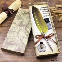 Feather pen set with ink bottle and decorative box on a wooden surface