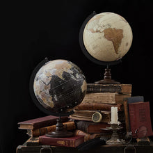 Two vintage-style globes on a stack of books with a black background