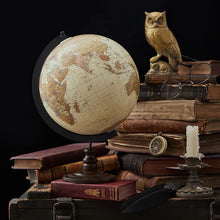 Vintage-style globe on books with an owl and glasses in the background