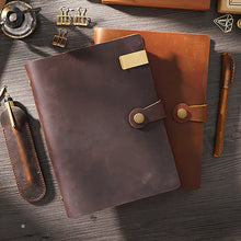 Brown leather notebook with pen on a wooden surface