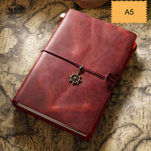 Red leather notebook with a charm on a vintage map background