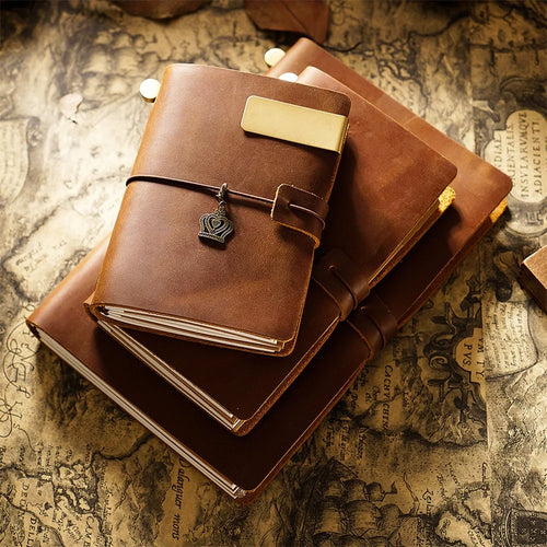Stack of brown leather journals on an old map background