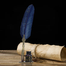 Blue feather quill pen with decorative holder and ink bottle on a wooden surface with a black background