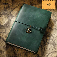 Green notebook with anchor charm on a vintage map background