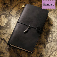 Black leather journal with a charm on an old map background, labeled 'Standard'.