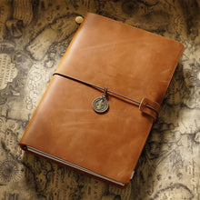 Brown leather notebook with a decorative charm on a vintage map background